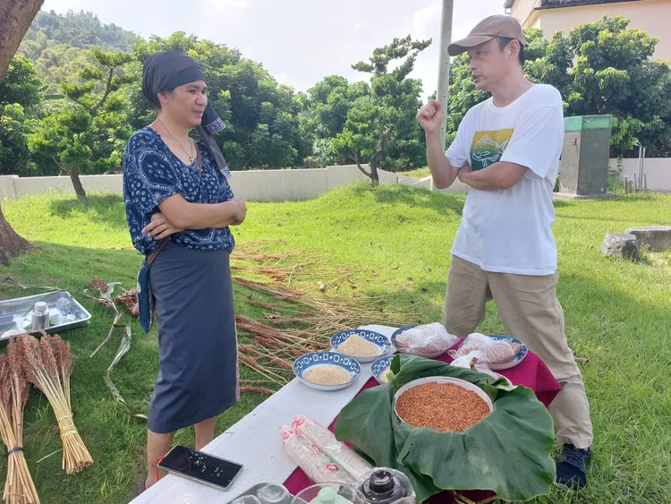 董景生(右)擔任民族植物輔導老師，協助復育傳統農糧。凃建豐攝