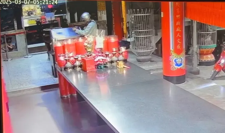 陳男拿油壓剪把鎖頭剪斷，一旁女信眾還不知發生何事。翻攝照片