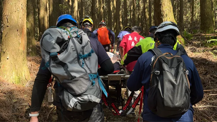 救難人員將李婦背負出特富野古道。翻攝畫面