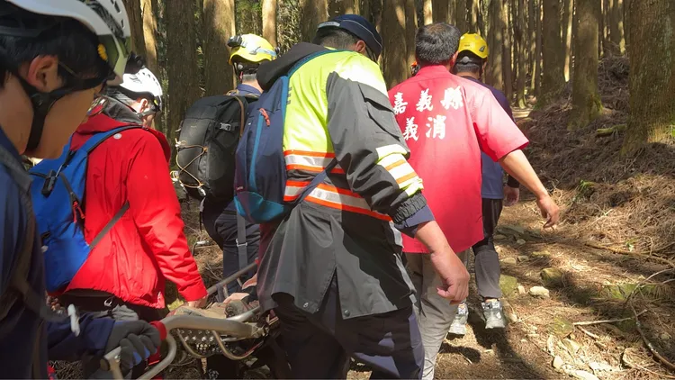 救難人員將李婦背負出特富野古道。翻攝畫面