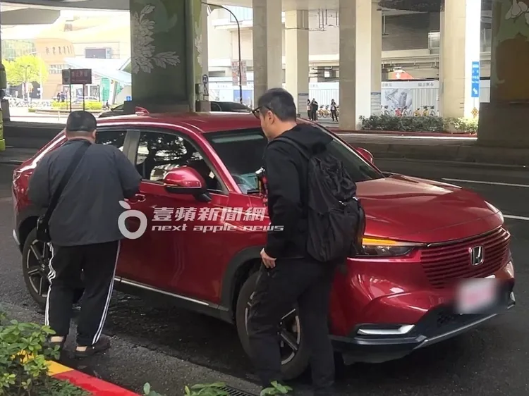 李銘忠（右）跟在友人身後上多元計程車。特勤中心攝