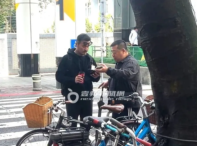 李銘忠（左）和友人確認預約的多元計程車抵達時間。特勤中心攝