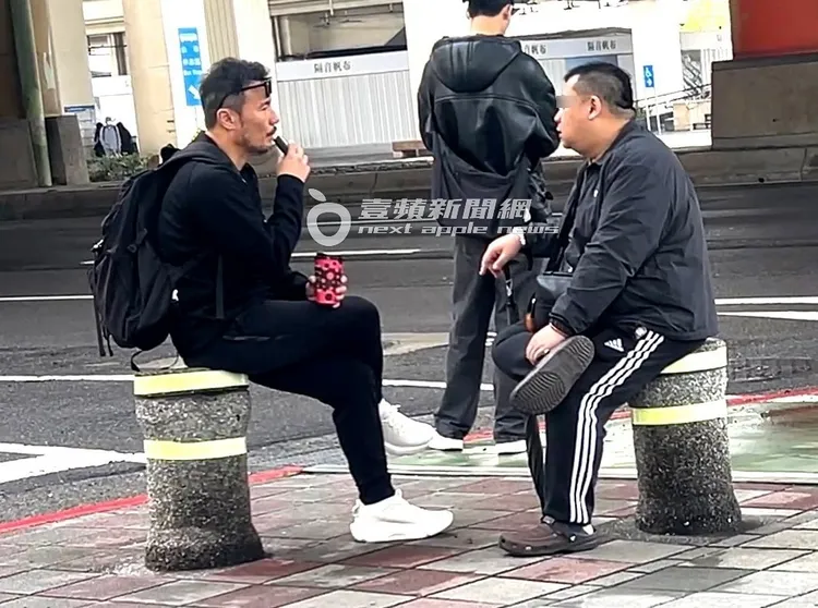 李銘忠（左）留和梁辰漢一樣的落腮鬍，坐路邊石柱上吸電子煙。特勤中心攝