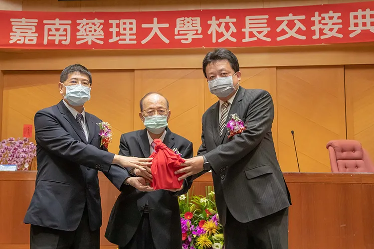 嘉藥董事長王昭雄主持嘉藥校長印信交接(中)，右為新任校長李孫榮教授，左為代理校長楊朝成教授)。取自嘉藥官網