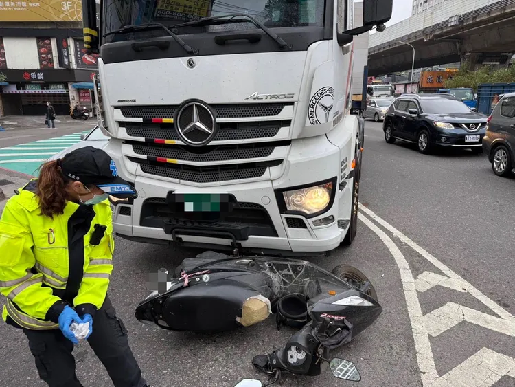 機車被壓在車頭，幸好騎士沒被捲入車底。翻攝畫面