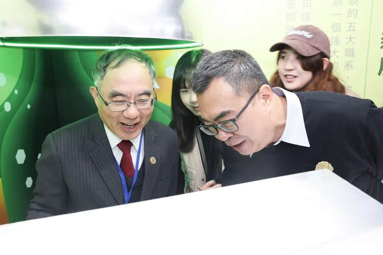 台大校長陳文章（圖左）親臨國泰攤位，參與國泰金控「職系分類帽」小遊戲，由國泰投信總經理張雍川（圖右）擔任職系領説員。國泰金控提供