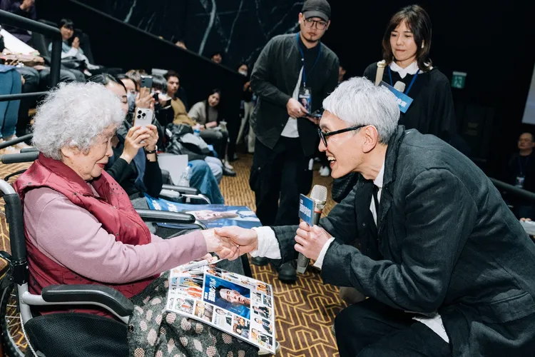 松重豐（右）蹲低身子，與97歲阿嬤粉絲握手。采昌國際提供