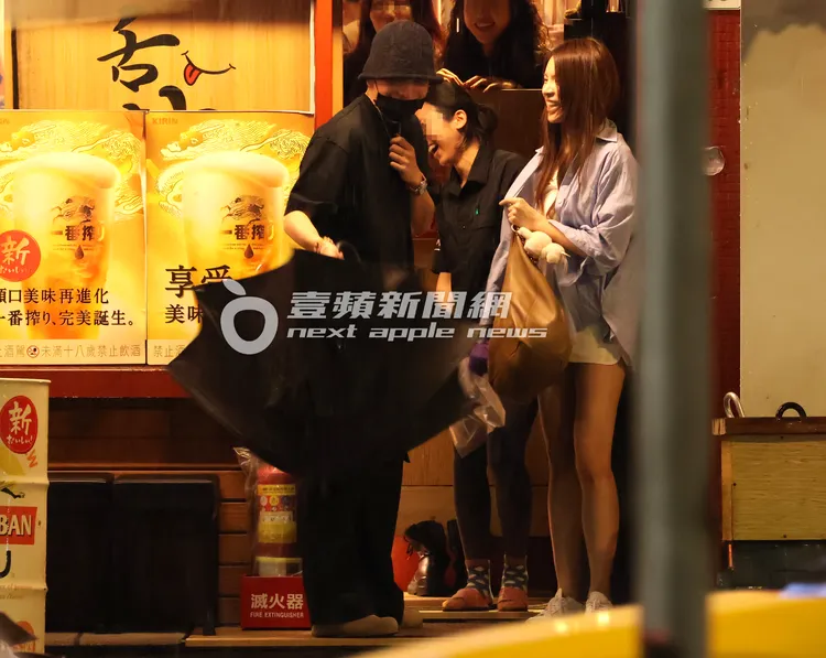 沐軒（右）穿好衣服，王大陸隨興拿起一把黑傘。特勤中心攝