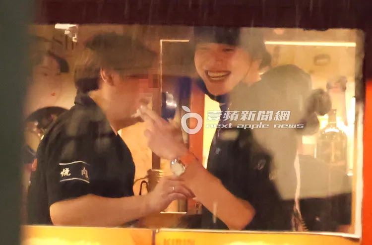 王大陸（右）手指夾著香菸吞雲吐霧，跟店員喝酒搏感情。特勤中心攝