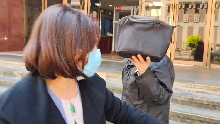 林朝榮拿著手提包遮掩不讓媒體拍攝。張欽攝