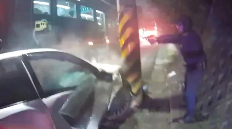 警員站在車側舉槍喝令嫌犯下車，而車上男女則因車體毀損而受困。翻攝畫面