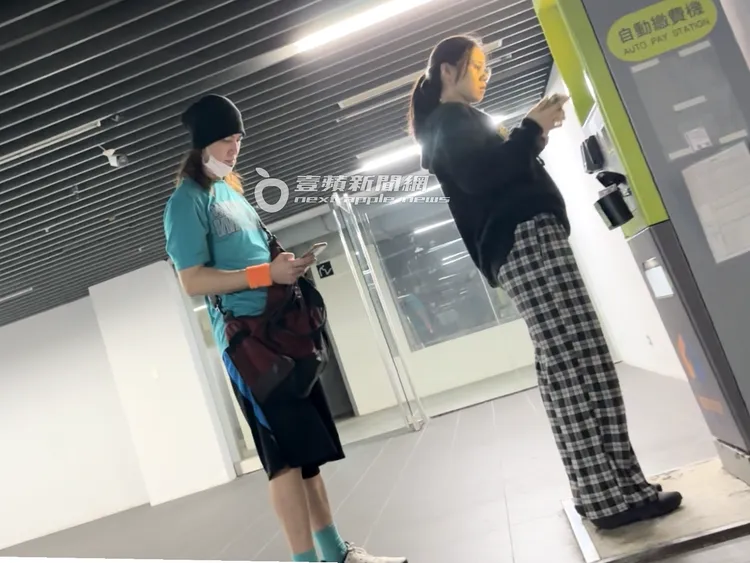 馬尾妹（右）拿出手機，準備將發票存入載具條碼中。特勤中心攝