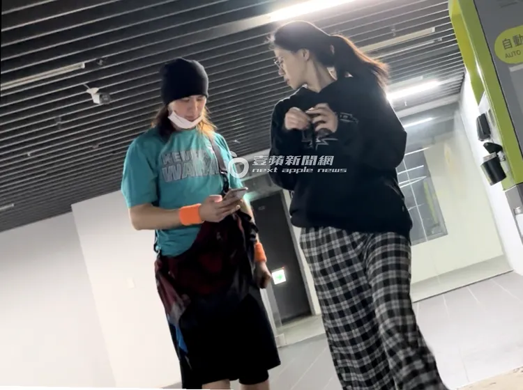 馬尾妹（右）繳完停車費，盯著陳楚河手機畫面，關心他在看什麼內容。特勤中心攝