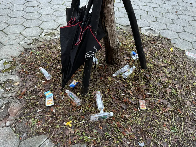 參加告別式的人群隨手將喝完的寶特瓶丟在樹木旁，連雨傘都未帶走。特勤中心攝