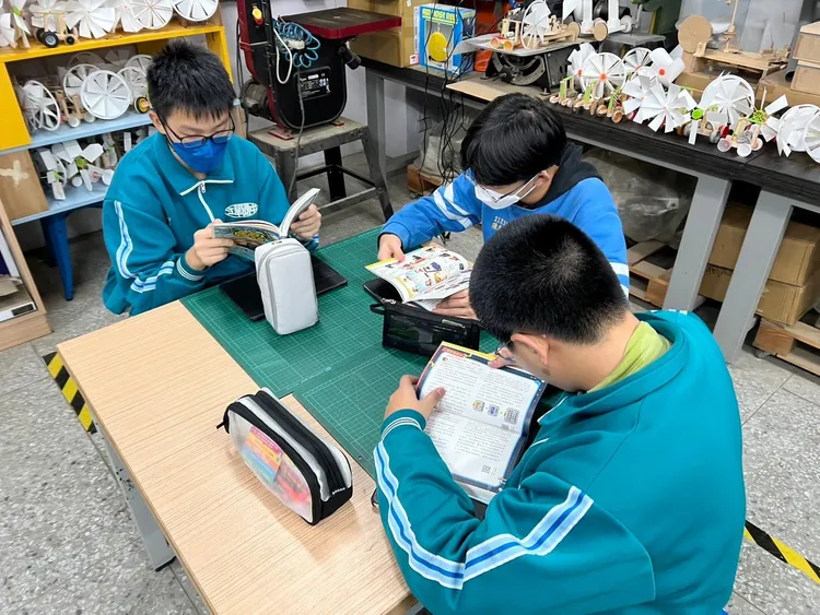 學生專心認真閱讀科普漫畫《阿宅聯盟：決戰AI太陽王國》。鴻海提供