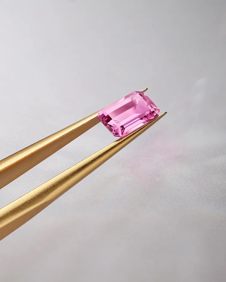 驚艷奪目的1克拉祖母綠型切工粉色藍寶石作為頂點點綴。品牌提供