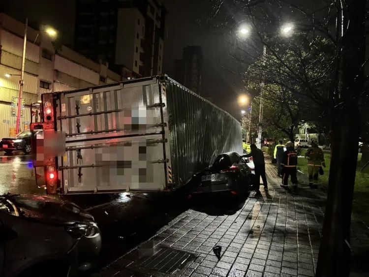 黑色轎車遭貨櫃砸中出現嚴重損毀。翻攝照片