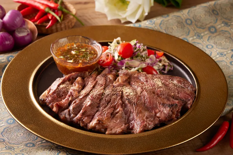 「炭烤澳洲和牛佐泰式辣醬」餐廳內人氣料理，嚴選肉質鮮嫩的澳洲 M9 和牛，搭配以魚露、青檸汁與辣椒調製的泰式經典辣醬。台北喜來登大飯店提供