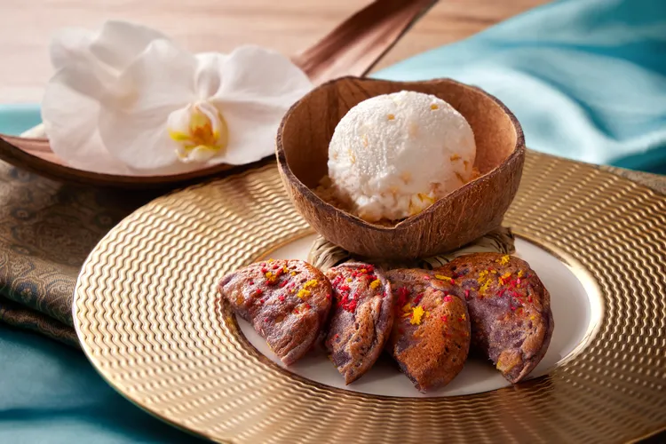 「古早味椰子煎餅搭泰式冰淇淋」以椰絲、椰奶與糯米粉製成的泰國椰子煎餅，外酥內軟且椰香濃郁，搭配主廚自製的風味冰淇淋，帶來冰火交融的味蕾體驗。台北喜來登大飯店提供