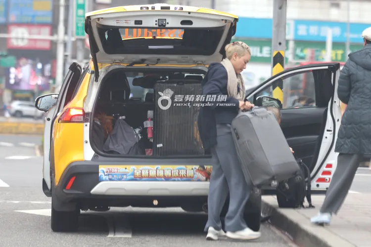 江振誠老婆Pam把行李箱搬下車。特勤中心攝