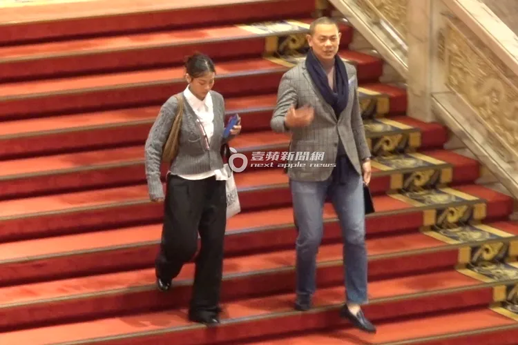 江振誠（右）與1名五官深邃的「馬尾妹」一同從圓山飯店下樓。特勤中心攝