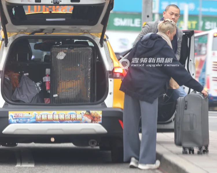 江振誠付完車資下車，幫忙老婆Pam拿行李箱。特勤中心攝
