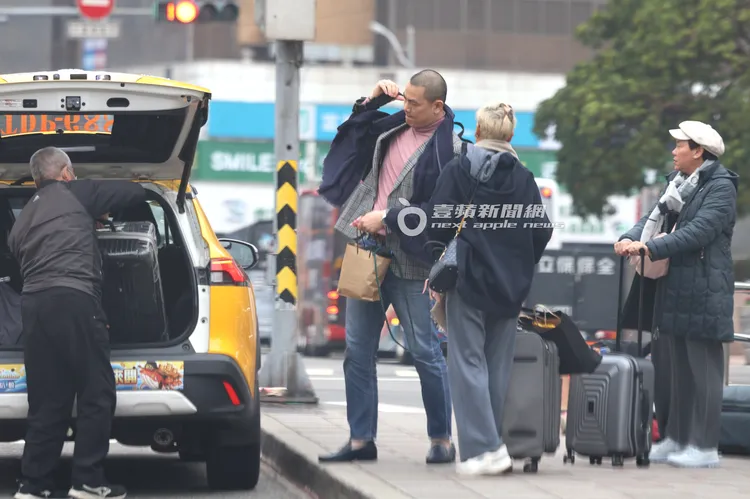 江振誠下車檢查隨身物品，跟老婆Pam、助理到台北車站東3門，準備搭高鐵。特勤中心攝