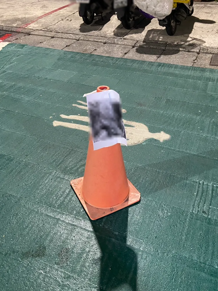 許男頭像被製成海報，張貼在三角錐上。翻攝畫面