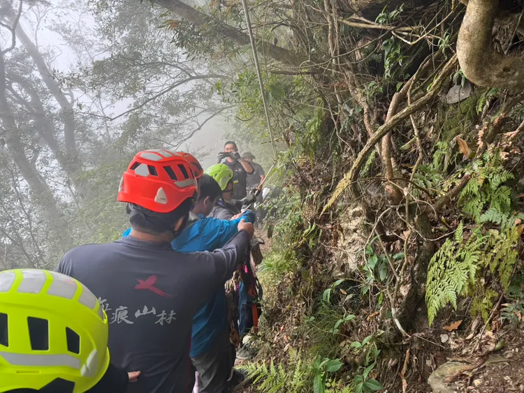 救援人員架設繩索垂降，將患者拖拉至步道。翻攝畫面