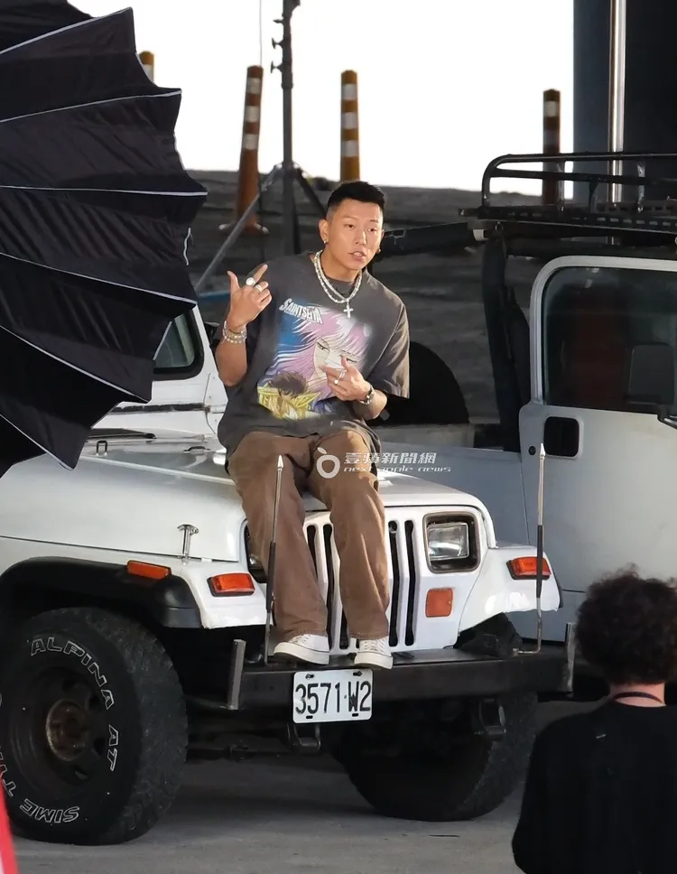 瘦子坐在吉普車車頭，開啟第一顆鏡頭。特勤中心攝