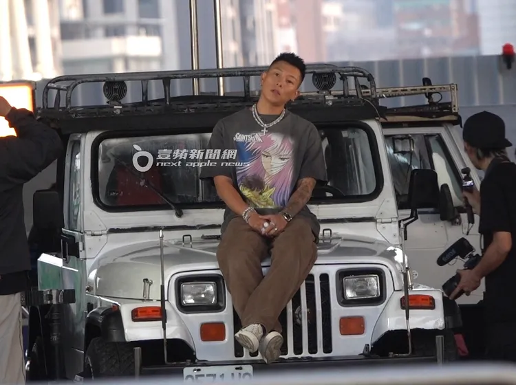 瘦子趁空檔坐在吉普車引擎蓋上放空休息。特勤中心攝