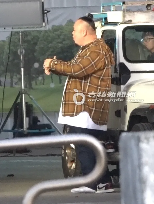 大淵換上Nike潮鞋穿到一半，即興拍攝對嘴鏡頭。特勤中心攝