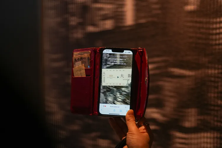 拿起手機在客房外走廊上對準模糊影像，來場西日本鐵道AR之旅。田欣雲攝影