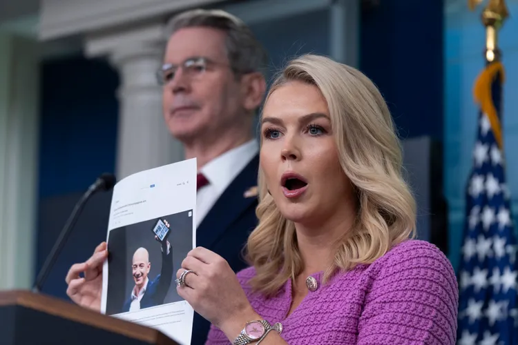 白宮新聞秘書李威特拿著亞馬遜創辦人貝佐斯的照片，痛批亞馬遜想標示「關稅附加費」。美聯社