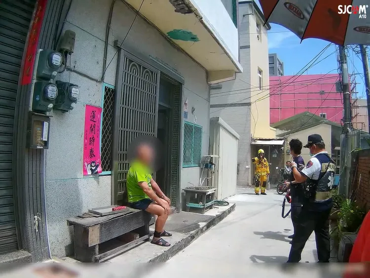 警察用警棍敲擊鐵窗，將屋主陳姓老翁喚醒，避免災害發生。翻攝畫面