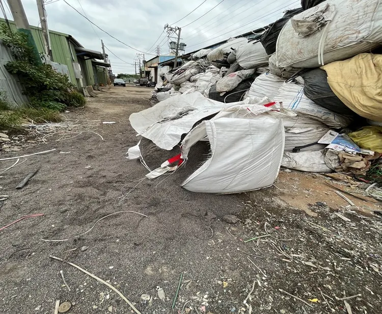 該公司非法貯存廢塑膠混合物容器破損廢棄物散布場址地面，屬非法行為。保七提供