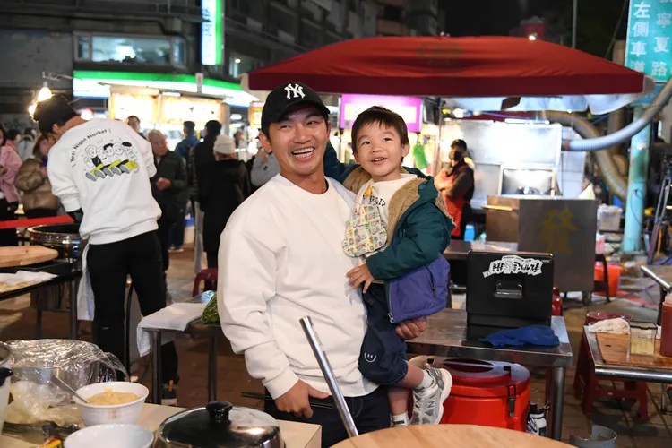 蔡昌憲（左）抱自己的小孩賣力吆喝。三立提供