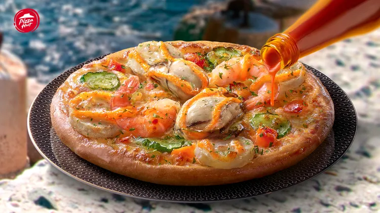 「明太子生蠔干貝獨享比薩」多種隱藏吃法引網友熱議，包含加入辣椒醬、花生醬等。必勝客提供