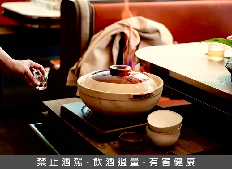 「雙臘煲仔飯」透過砂鍋燜煮與高粱點火儀式，鎖住臘味油脂香氣，每一口米飯都裹著肉香酒香。業者提供