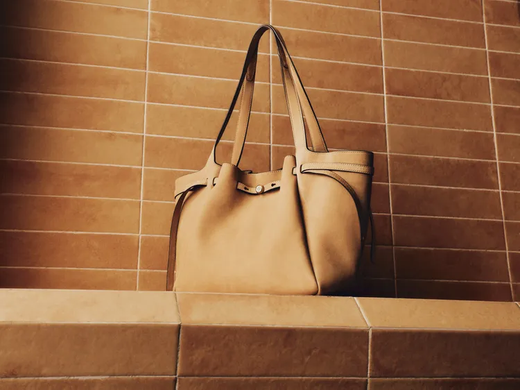 TORY BURCH ROMY托特包於頂部以收攏線條呈現出獨特結構。品牌提供