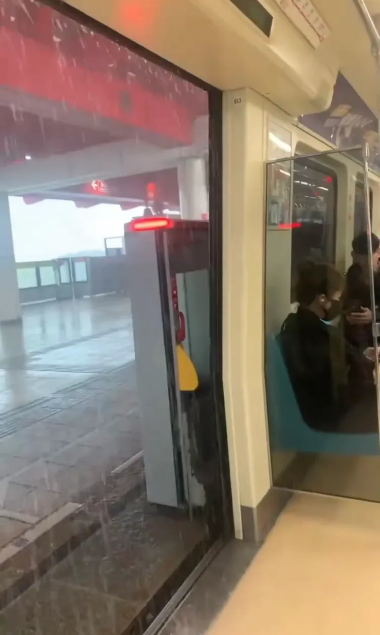 淡水捷運站雨水灌進車廂，車門如同水濂洞瀑布，造成車廂內地板積水。擷取自threads帳號henhenjack0609 