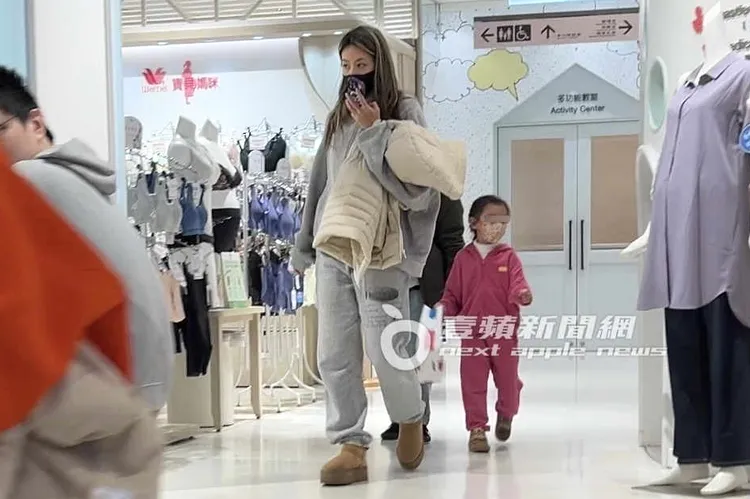 蔡詩芸（左）拿著女兒外套牽著她，在百貨公司逛街。特勤中心攝