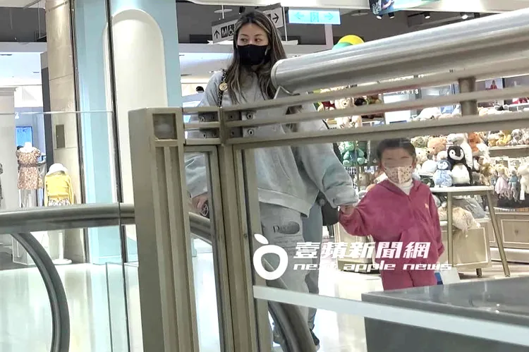 上完黏土課，蔡詩芸牽女兒往手扶梯移動。特勤中心攝