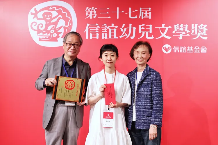 幼兒圖畫書首獎由鄭萱婕(圖中)創作的《來，我跟你說—地球人聽話指南》奪得。頒獎時她與信誼基金會董事長張杏如(圖右)、文化部長李遠(圖左)合影。許麗珍