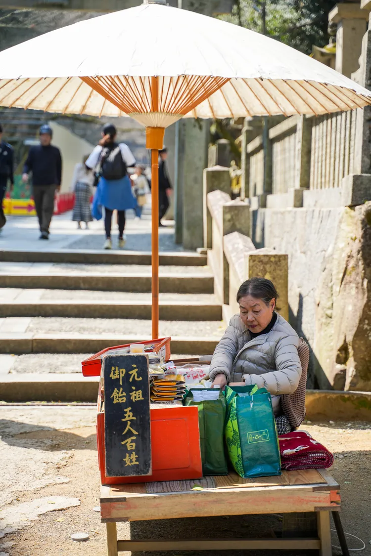 五人百姓在大門內販售傳統糖果「加美代飴」。田欣雲攝影
