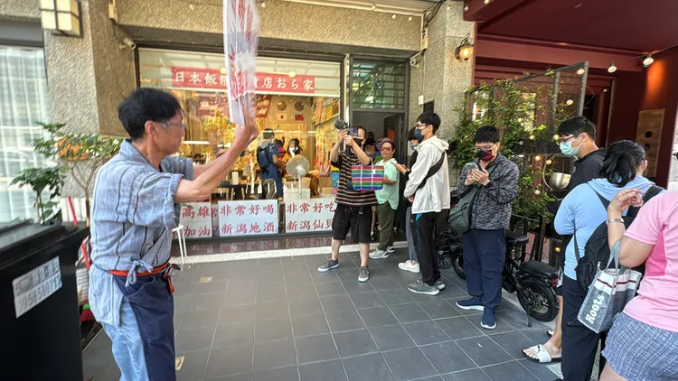 樋口先生舉牌感謝來排隊的客人。民眾提供