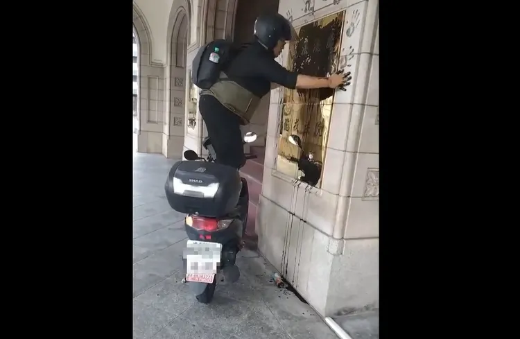 田山盛國踩在機車上蓋黑手印。資料照片