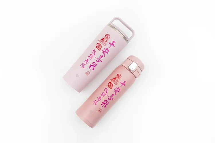 兩款媽祖祝福保溫杯的粉色系瓶身，印有白沙屯媽祖圖象，更配有祝福語「平安喜樂、效期無限」。昇恆昌免稅商店提供