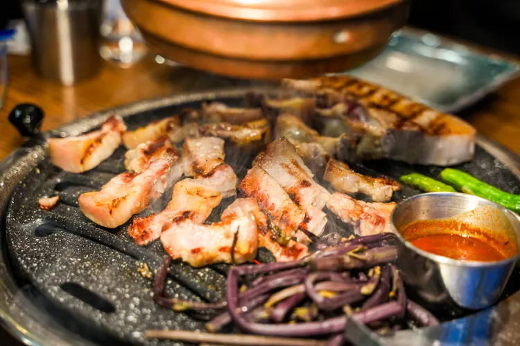 黑豬肉在烤盤上滋滋作響，搭配一旁附上的鯷魚醬（멜젓），最是對味。田欣雲攝影