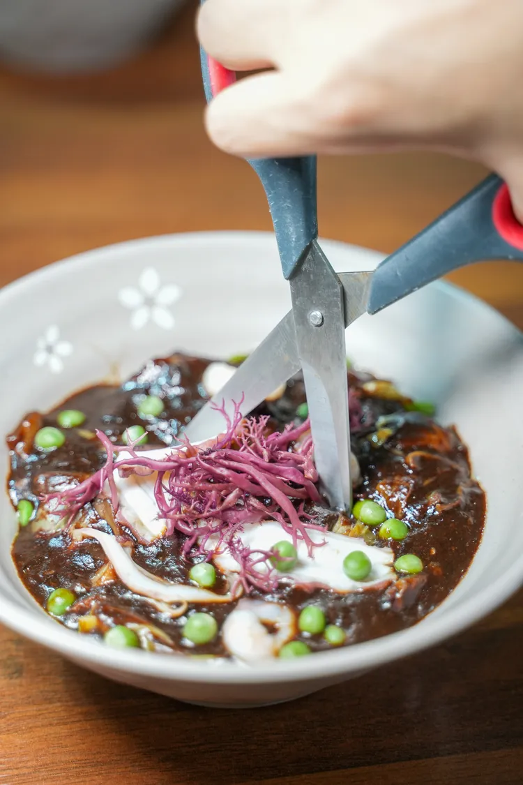 海鮮炸醬麵享用之前，要先拿剪刀將麵剪開。田欣雲攝影